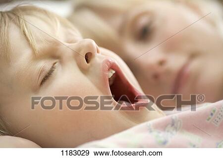 A young girl and her mother waking up in the morning View Large Photo Image Stock Photo - A young girl and her mother waking up in the morning. Fotosearch
