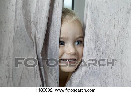 A young girl hiding between window curtains View Large Photo Image Stock Image - A young girl hiding between window curtains. Fotosearch