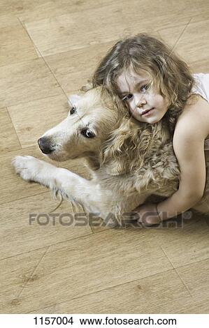 Picture - A young girl hugging a dog. Fotosearch