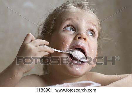 A young girl making a mess out of eating yogurt View Large Photo Image Stock Image - A young girl making a mess out of eating yogurt. Fotosearch