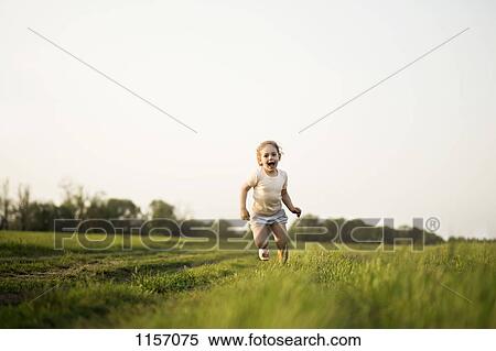 A young girl running in a field View Large Photo Image Stock Photography - A young girl running in a field. Fotosearch