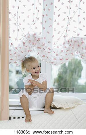 A young girl sitting on a window sill, clapping hands excitedly View Large Photo Image Stock Photography - A young girl sitting on a window sill, clapping hands excitedly. Fotosearch