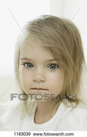 A young girl with a tear falling down her cheek View Large Photo Image Stock Photo - A young girl with a tear falling down her cheek. Fotosearch