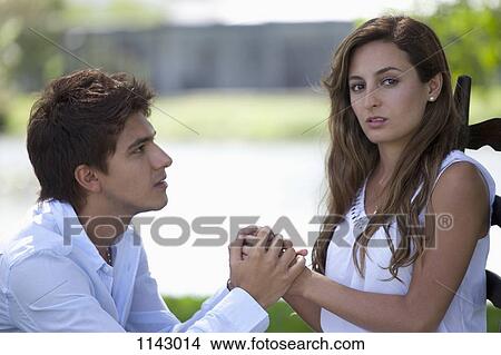 A young man holding the hands of a young woman View Large Photo Image Picture - A young man holding the hands of a young woman. Fotosearch