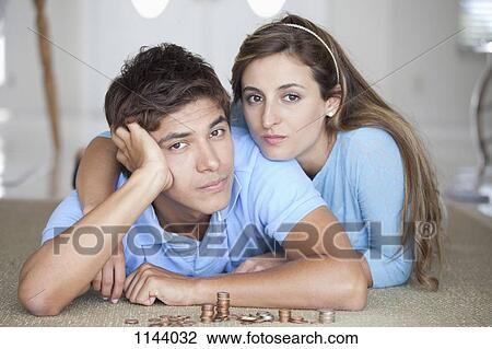 A young serious couple lying on the floor near stacks of coins View Large Photo Image Stock Image - A young serious couple lying on the floor near stacks of coins. Fotosearch