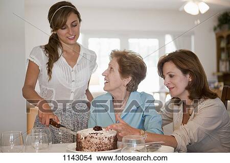 A young woman serving cake for her mother and grandmother View Large Photo Image Picture - A young woman serving cake for her mother and grandmother. Fotosearch