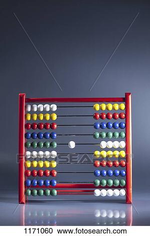 An abacus with neat rows of multi colored beads and a single white bead in the middle View Large Photo Image Stock Image - An abacus with neat rows of multi colored beads and a single white bead in the middle. Fotosearch