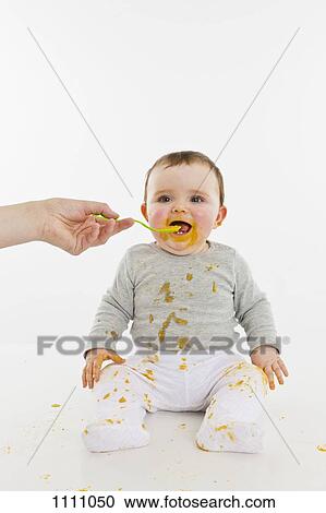 An adult feeding a baby View Large Photo Image Stock Image - An adult feeding a baby. Fotosearch