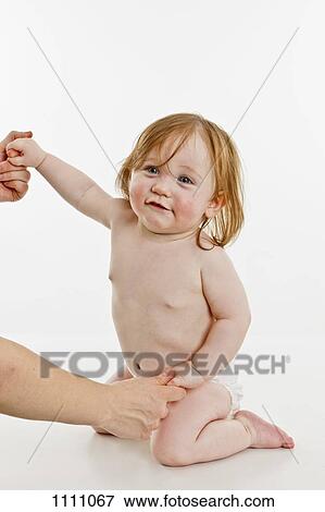 An adult holding the hands of a baby girl View Large Photo Image Stock Photo - An adult holding the hands of a baby girl. Fotosearch