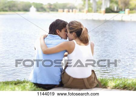 An affectionate couple kissing by a lake, rear view View Large Photo Image Stock Photo - An affectionate couple kissing by a lake, rear view. Fotosearch