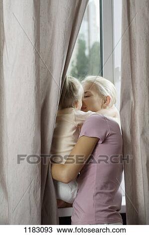An affectionate mother and daughter at a window View Large Photo Image Stock Image - An affectionate mother and daughter at a window. Fotosearch