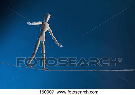 Stock Photo - An artist's figure walking a tightrope. Fotosearch