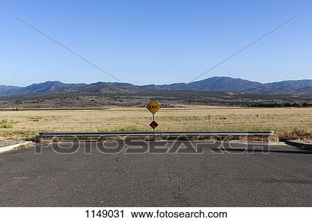 Stock Image - An END road sign and mountain ranges behind. Fotosearch