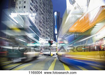 Picture - Buses moving through a city at night, blurred motion. Fotosearch