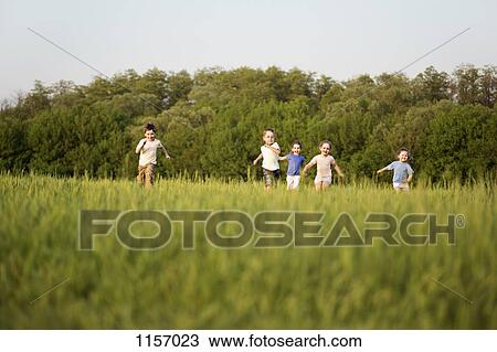 Children running in a field View Large Photo Image Stock Image - Children running in a field. Fotosearch