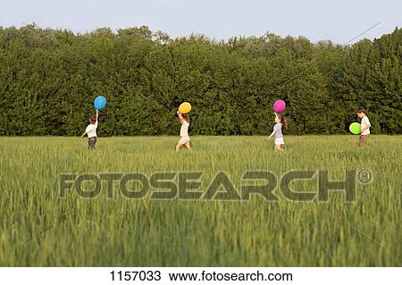 Children walking in a field with balloons View Large Photo Image Stock Image - Children walking in a field with balloons. Fotosearch