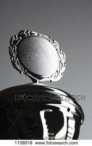 Close-up of a silver trophy with blank plaque surrounded by laurel wreath View Large Photo Image Stock Photo - Close-up of a silver trophy with blank plaque surrounded by laurel wreath. Fotosearch