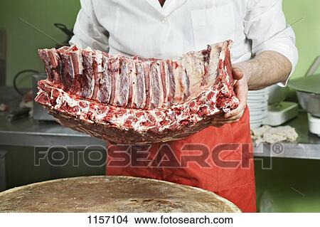 Detail of a butcher holding a rack of meat View Large Photo Image Picture - Detail of a butcher holding a rack of meat. Fotosearch