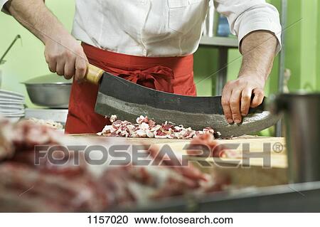 Detail of a man chopping meat with a large knife View Large Photo Image Stock Image - Detail of a man chopping meat with a large knife. Fotosearch