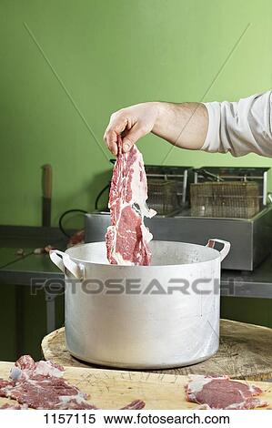 Detail of a man putting meat into a large saucepan View Large Photo Image Stock Photography - Detail of a man putting meat into a large saucepan. Fotosearch