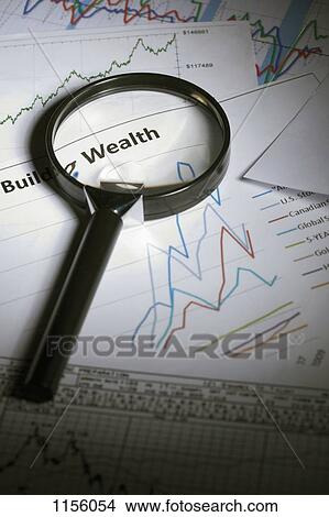 Financial paperwork with a magnifying glass on top View Large Photo Image Picture - Financial paperwork with a magnifying glass on top. Fotosearch