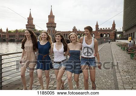 Stock Photography - Five female friends walking side by side near the Oberbaumbruecke, Berlin, Germany. Fotosearch