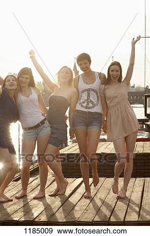 Five young female friends celebrating on a jetty, Spree River, Berlin, Germany View Large Photo Image Stock Photo - Five young female friends celebrating on a jetty, Spree River, Berlin, Germany. Fotosearch