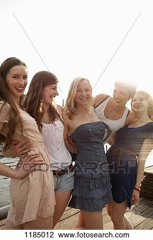 Five young female friends together on a jetty View Large Photo Image Stock Image - Five young female friends together on a jetty. Fotosearch