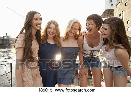 Stock Photography - Five young women standing on a jetty next to the Spree River, Berlin, Germany. Fotosearch