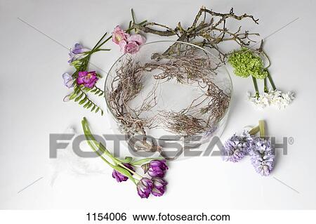 Flowers lying on a table around a glass bowel vase View Large Photo Image Stock Photograph - Flowers lying on a table around a glass bowel vase. Fotosearch
