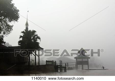 Stock Image - Fog surrounding a village on Inle Lake, Burma. Fotosearch
