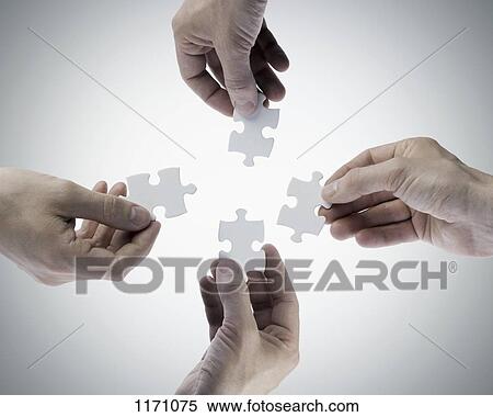 Four hands holding jigsaw puzzle pieces, directly above View Large Photo Image Stock Photography - Four hands holding jigsaw puzzle pieces, directly above. Fotosearch