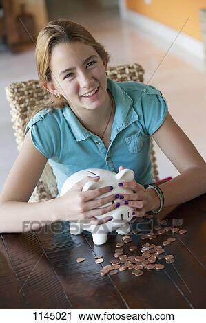 Stock Image - Girl holding piggy bank. Fotosearch