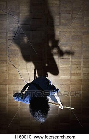 Guitarist sitting on stage in spotlight View Large Photo Image Stock Image - Guitarist sitting on stage in spotlight. Fotosearch