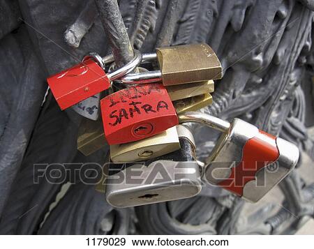 Lovelocks of passion on a bridge, attached by couples as a symbol their devotion View Large Photo Image Stock Photo - Lovelocks of passion on a bridge, attached by couples as a symbol their devotion. Fotosearch