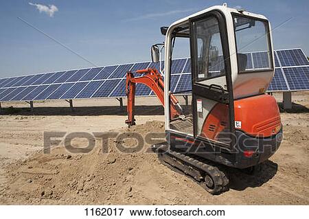 Mechanical digger on solar panel construction site View Large Photo Image Stock Photo - Mechanical digger on solar panel construction site. Fotosearch