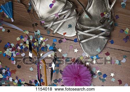 Metallic strappy heels, confetti and streamers littering a hardwood floor View Large Photo Image Stock Photo - Metallic strappy heels, confetti and streamers littering a hardwood floor. Fotosearch