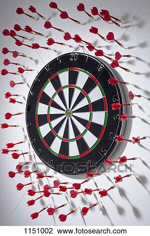 Multiple darts stuck in a wall all around a dartboard View Large Photo Image Stock Image - Multiple darts stuck in a wall all around a dartboard. Fotosearch
