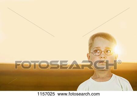 Stock Photography - Portrait of a boy in a field at sunset. Fotosearch