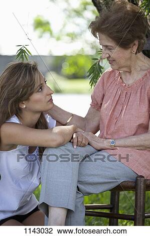 Portrait of a senior woman and a young woman sitting together outside View Large Photo Image Stock Image - Portrait of a senior woman and a young woman sitting together outside. Fotosearch