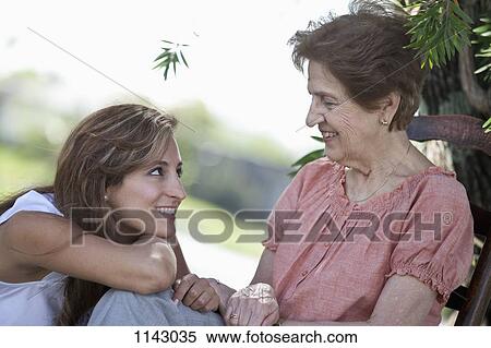 Stock Photography - Portrait of a senior woman and a young woman sitting together outside. Fotosearch