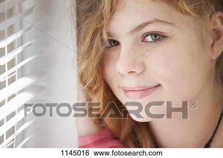 Stock Photograph - Portrait of girl by window. Fotosearch