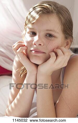 Stock Image - Portrait of girl on bed. Fotosearch