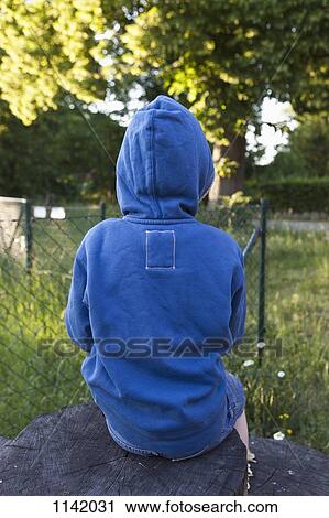 Rear view of a boy sitting on a tree stump View Large Photo Image Stock Image - Rear view of a boy sitting on a tree stump. Fotosearch