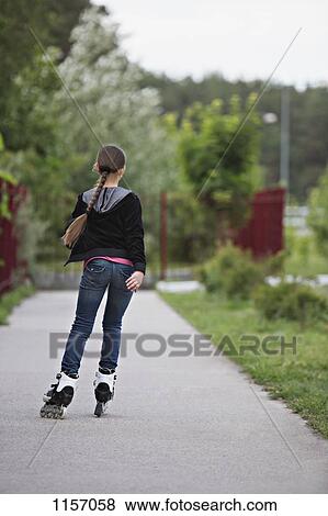 Rear view of a girl inline skating View Large Photo Image Stock Photo - Rear view of a girl inline skating. Fotosearch