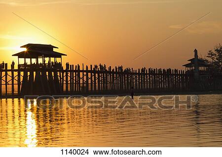 Silhouette of people crossing U Bein Bridge at sunset, Amarapura, Burma View Large Photo Image Picture - Silhouette of people crossing U Bein Bridge at sunset, Amarapura, Burma. Fotosearch