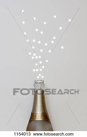Star shaped confetti spraying out of a champagne bottle View Large Photo Image Stock Image - Star shaped confetti spraying out of a champagne bottle. Fotosearch