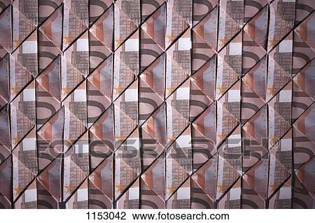 Stock Image - Ten Euro banknotes folded into diamond shapes and interwoven, full frame. Fotosearch