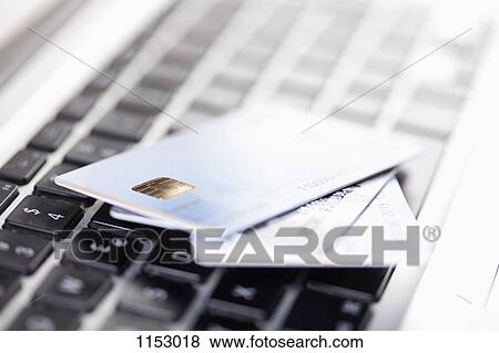 Three credit cards lying on a laptop keyboard View Large Photo Image Stock Photo - Three credit cards lying on a laptop keyboard. Fotosearch