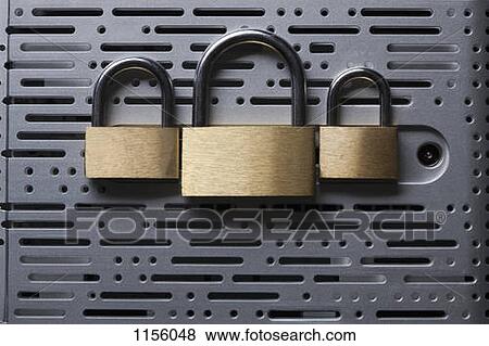 Stock Photo - Three padlocks lying on the back of a computer hard drive. Fotosearch